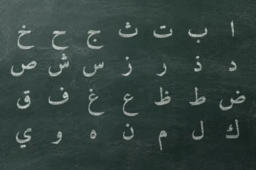 Ardoise où les 28 lettres de l’alphabet arabe sont écrites à la craie dans l’ordre hija’i, en quatre rangées de sept