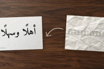 Feuille froissée couverte de carrés vides (tofu), flèche au crayon, puis carte nette où « Ahlan wa sahlan » s'affiche en Amiri Bold