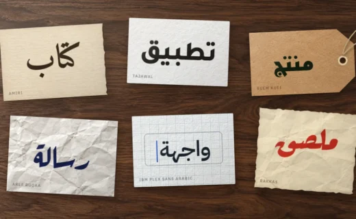 Six papiers sur un bureau en noyer, chacun avec un mot arabe en Amiri, Tajawal, Reem Kufi, Aref Ruqaa, IBM Plex Sans Arabic ou Rakkas